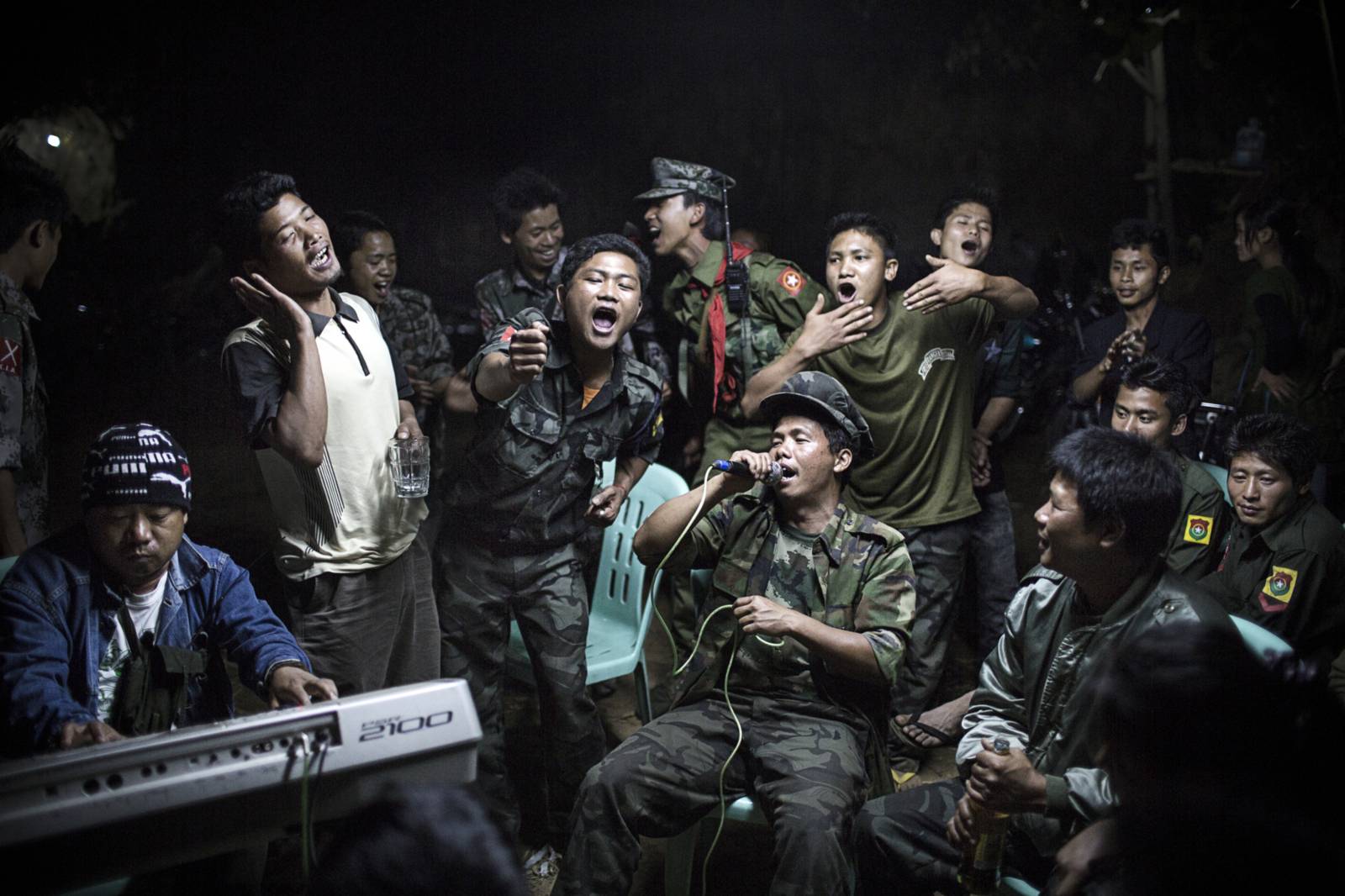 Singende und tanzende burmesische Rebellen bei einer Trauerfeier.